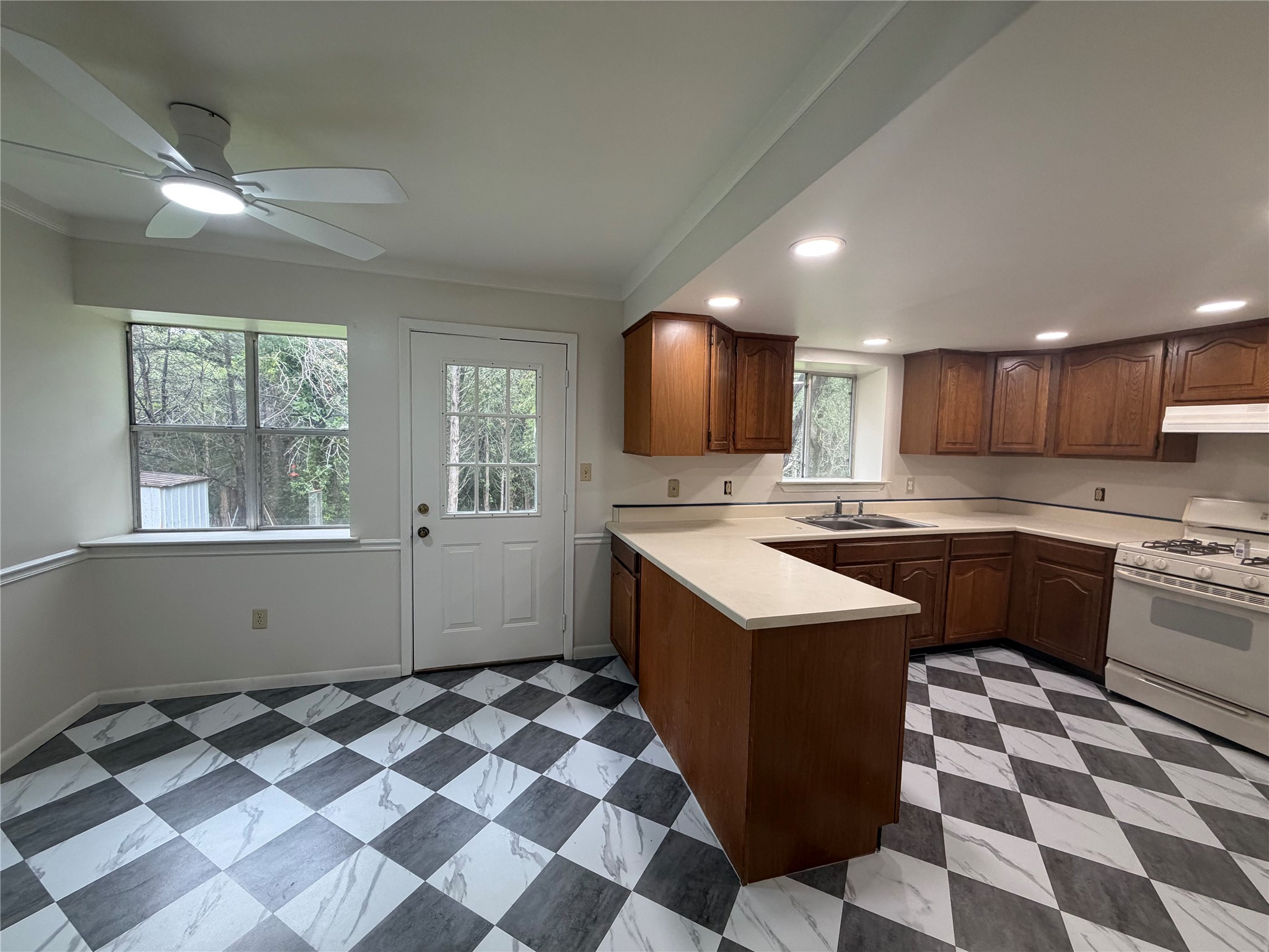 214 The Forest Road Dale, TX 78616 - Photo 5 of 18 A well-lit kitchen with classic checkerboard flooring and abundant cabinetry awaits your culinary adventures.