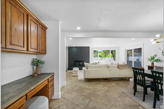 432 Calnette Drive Sandy, UT 84070 - Photo 13 of 48 Open-concept living space with a built-in desk area featuring wood cabinetry and a dark countertop