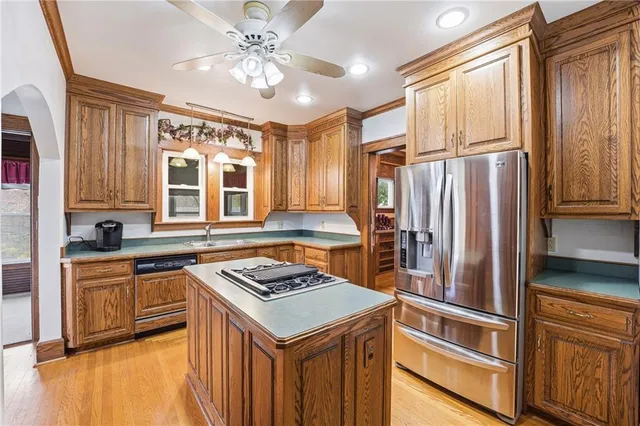 a kitchen with kitchen island granite countertop a sink appliances cabinets and a counter top space