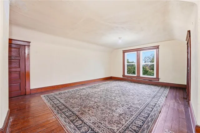 an empty room with wooden floor and window