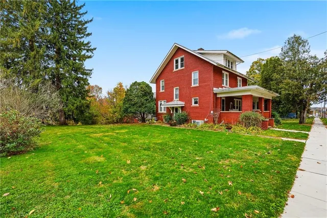 a front view of house with yard and green space