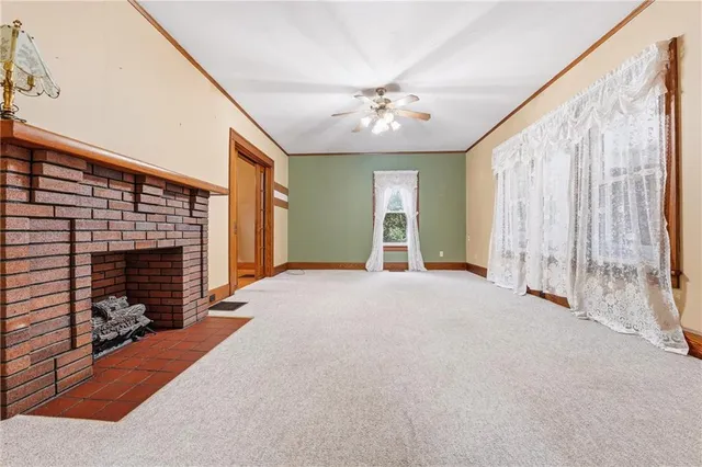 a view of an empty room with a fireplace and a window
