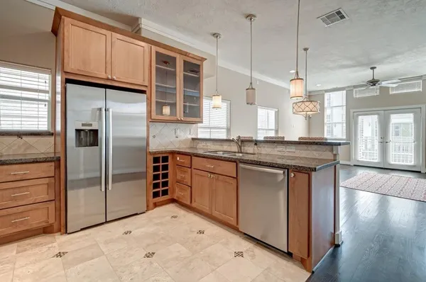 a kitchen with stainless steel appliances granite countertop a sink a stove and a refrigerator