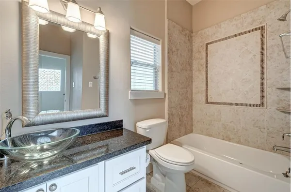a bathroom with a granite countertop sink toilet and mirror