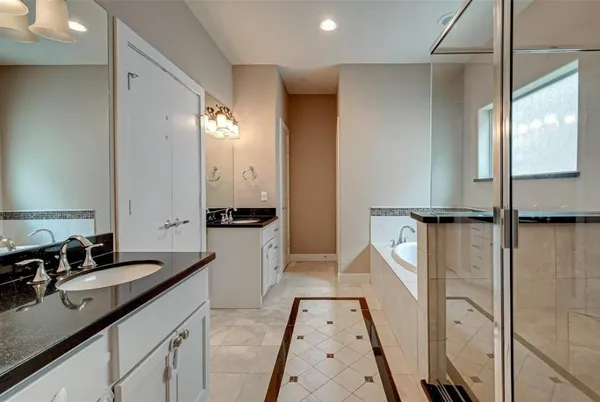 a spacious bathroom with a double vanity sink a mirror and a shower