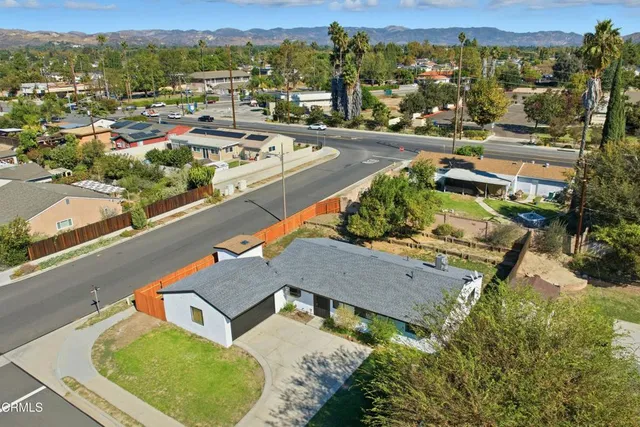 an aerial view of a city with lots of residential buildings and ocean view in back