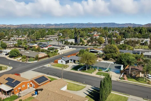 an aerial view of a house with a yard and large tree