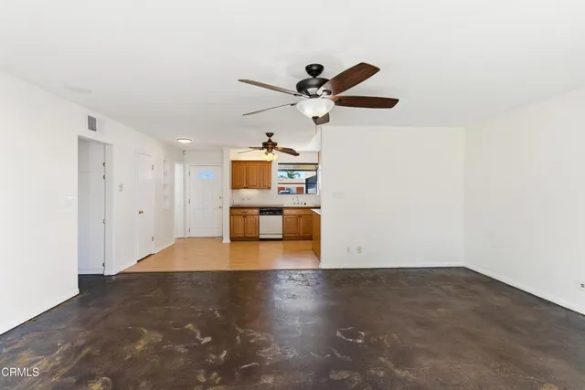 a view of a room with wooden floor and a ceiling fan