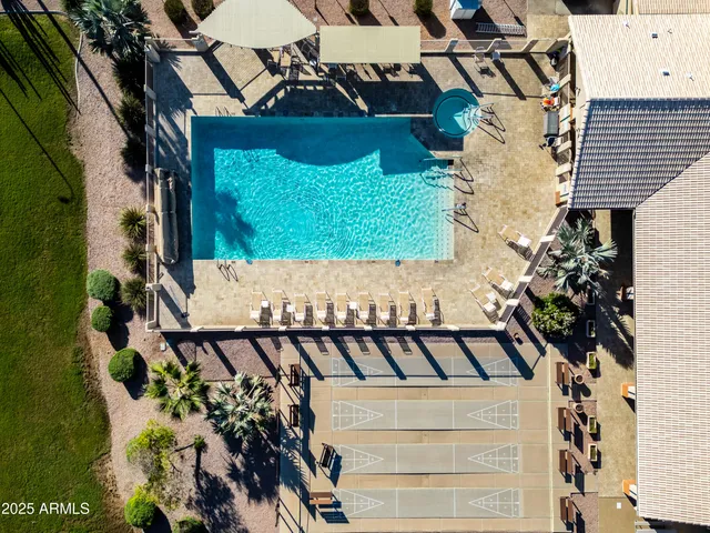 an aerial view of a swimming pool with outdoor seating