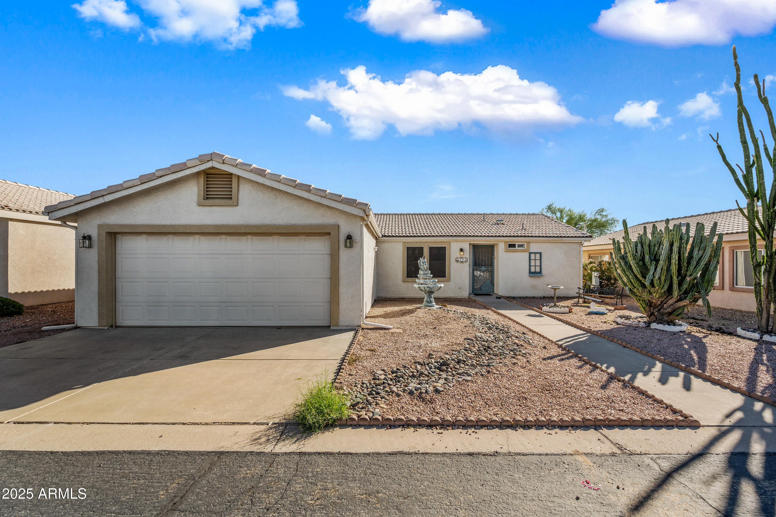 2101 South Meridian Road, Unit 49 Apache Junction, AZ 85120 - Photo 3 of 44 a front view of a house with a yard and garage