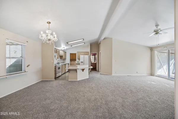 a large white kitchen with stainless steel appliances granite countertop a stove and a sink