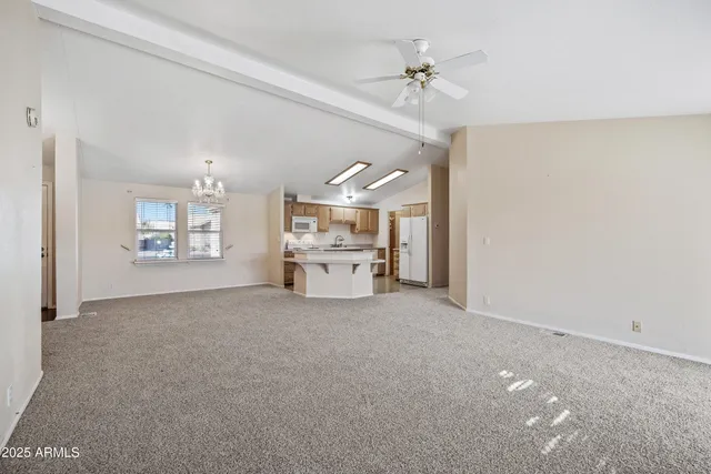 en empty room with windows and chandelier