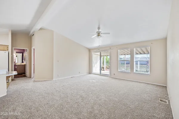 en empty room with windows and chandelier