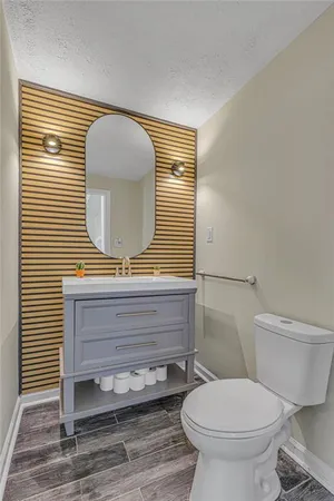 a bathroom with a toilet a sink and mirror