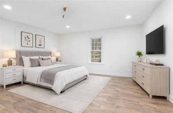 a bedroom with a large bed and a flat screen tv