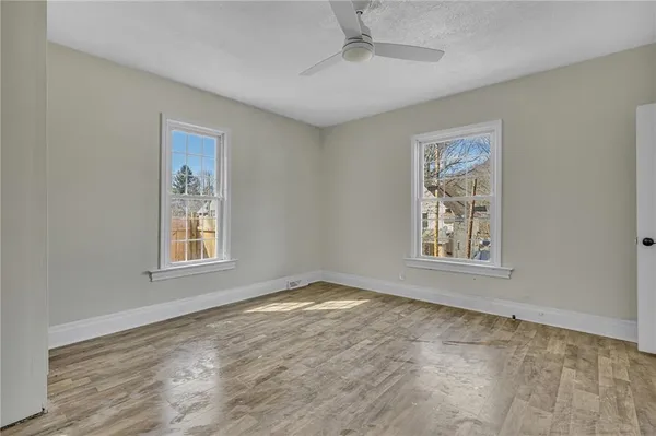 a view of an empty room with a window and closet area