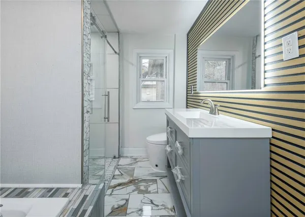 a bathroom with a sink a toilet and shower