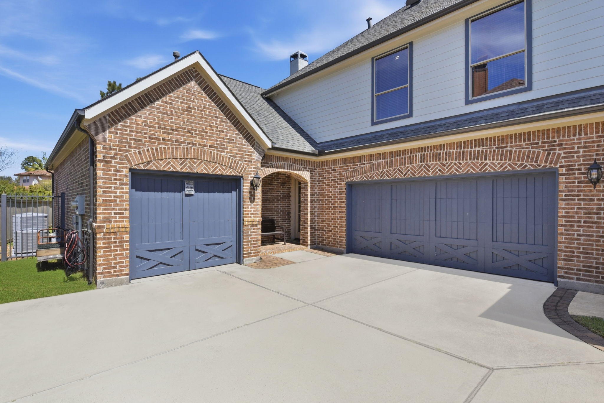 223 South Bauer Point Circle Spring, TX 77389 - Photo 2 of 50 This photo shows a modern three-car garage with blue doors, set against a brick exterior. The driveway is spacious, and there's a small, covered entryway leading to the home.