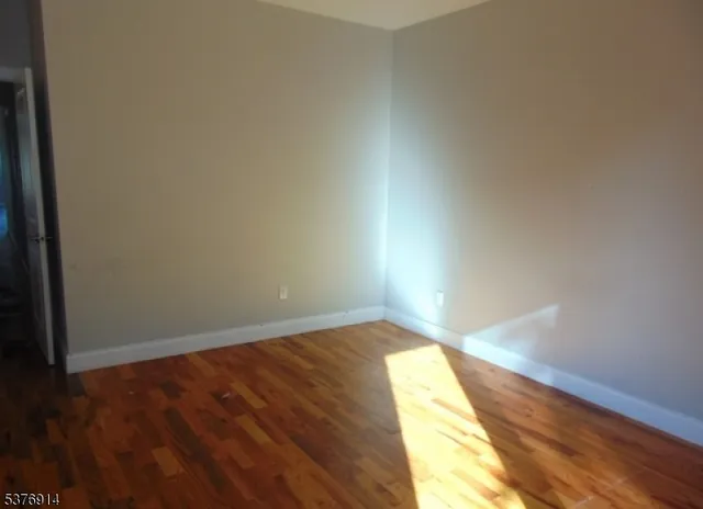 a view of an empty room and wooden floor