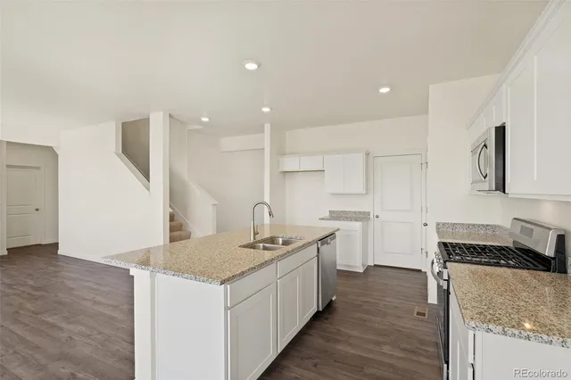 a kitchen with a sink stove and cabinets