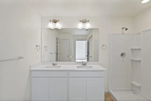 a bathroom with a sink a large mirror and shower
