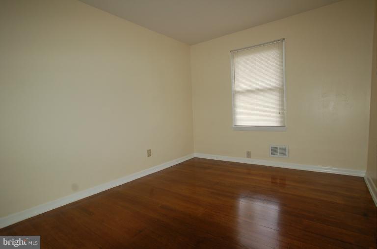 7909 Clark Station Road Severn, MD 21144 - Photo 9 of 11 an empty room with wooden floor and windows