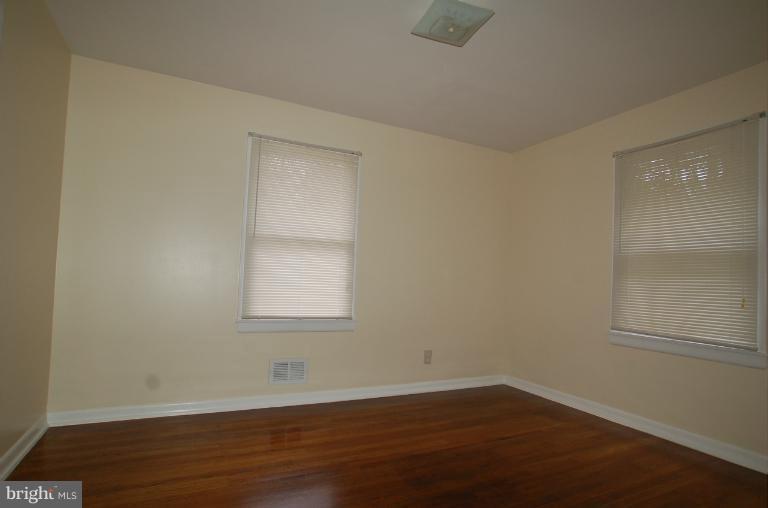 7909 Clark Station Road Severn, MD 21144 - Photo 10 of 11 an empty room with wooden floor and windows