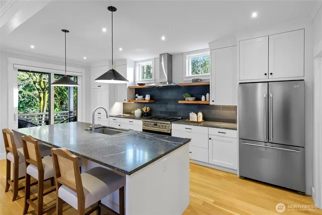 a kitchen with kitchen island a large counter top space appliances and cabinets