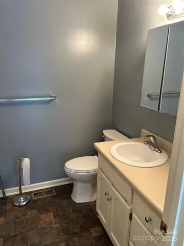 a white toilet sitting next to a bathroom sink