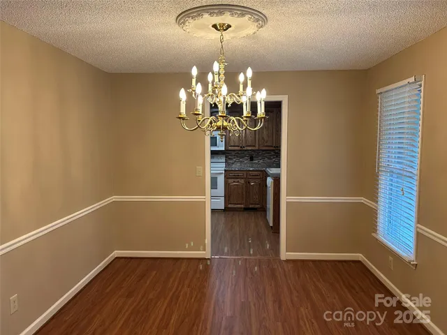 a view of a room with wooden floor and chandelier
