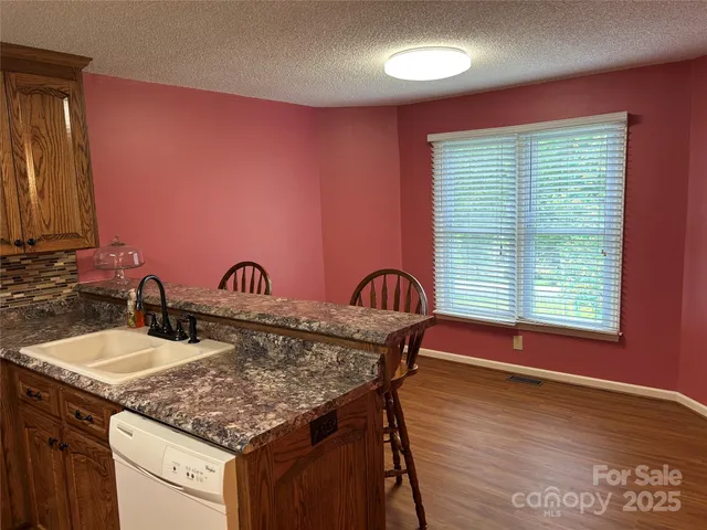 a kitchen with a sink cabinets and wooden floor
