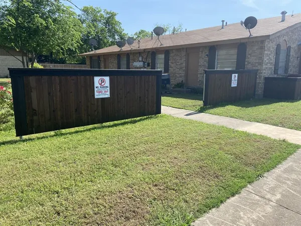 a view of backyard of house and wooden fence
