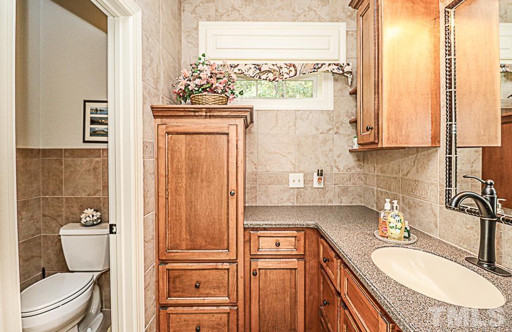 7400 Lancaster Store Road Spring Hope, NC 27882 - Photo 45 of 86 a bathroom with a granite countertop toilet sink and mirror