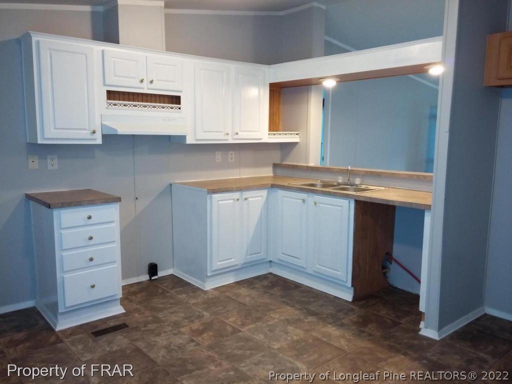 358 Capel Mill Road Candor, NC 27229 - Photo 3 of 11 a room with granite countertop white cabinets and sink