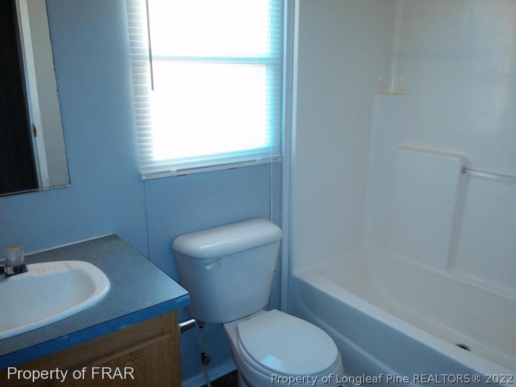 358 Capel Mill Road Candor, NC 27229 - Photo 9 of 11 a white toilet sitting next to a bath tub