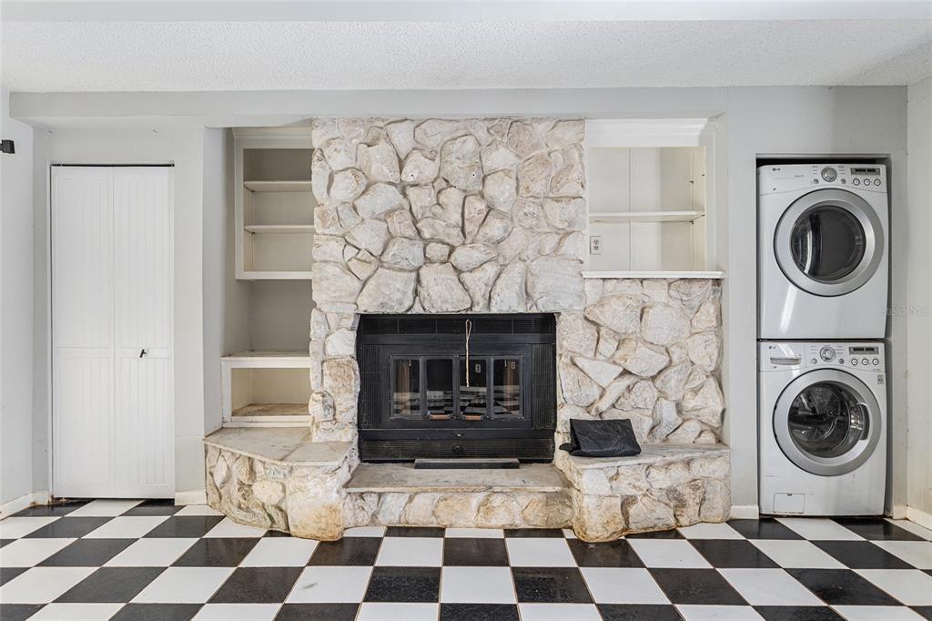 9951 Southwest 88th Court Road, Unit C Ocala, FL 34481 - Photo 14 of 46 a room with a black white checkered floor and a fireplace