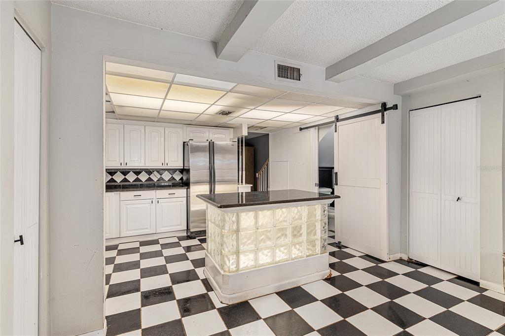 9951 Southwest 88th Court Road, Unit C Ocala, FL 34481 - Photo 17 of 46 a hallway with white cabinets and black and white checkered floor
