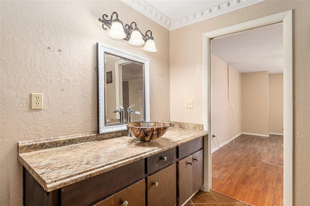 9951 Southwest 88th Court Road, Unit C Ocala, FL 34481 - Photo 27 of 46 a bathroom with a granite countertop sink and a mirror