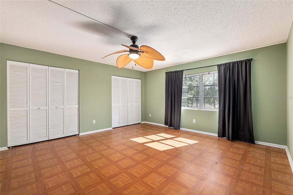 9951 Southwest 88th Court Road, Unit C Ocala, FL 34481 - Photo 31 of 46 a view of an empty room with window and chandelier fan