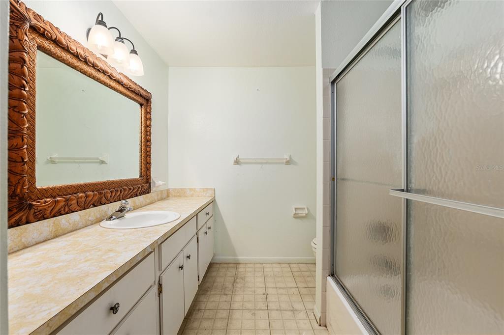 9951 Southwest 88th Court Road, Unit C Ocala, FL 34481 - Photo 33 of 46 a bathroom with a double vanity sink and mirror