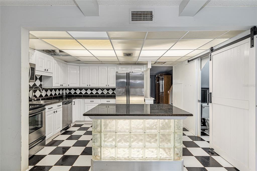 9951 Southwest 88th Court Road, Unit C Ocala, FL 34481 - Photo 10 of 46 a kitchen with stainless steel appliances granite countertop a sink and a refrigerator