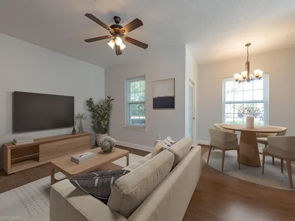 a living room with furniture a chandelier and a flat screen tv