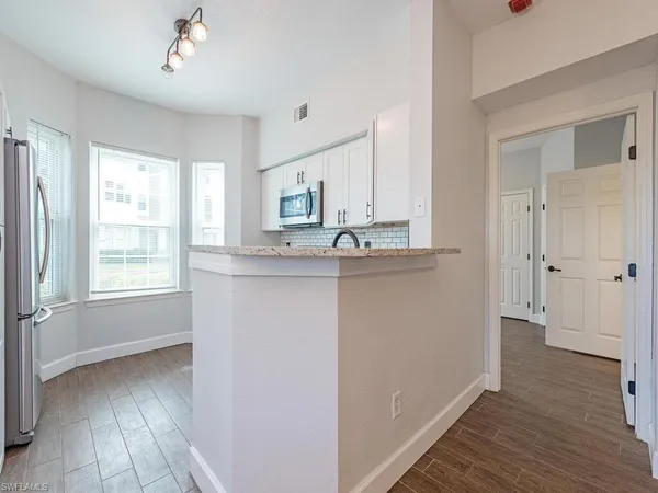 a kitchen with kitchen island granite countertop a sink cabinets and wooden floor