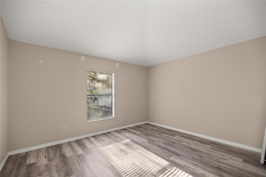 9680 Southwest 30th Terrace Ocala, FL 34476 - Photo 12 of 27 a view of empty room with wooden floor and fan
