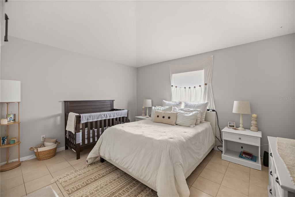 9680 Southwest 30th Terrace Ocala, FL 34476 - Photo 22 of 27 a bedroom with a bed and a lamp