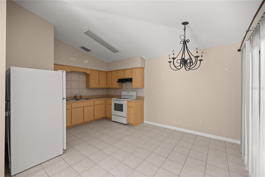 9680 Southwest 30th Terrace Ocala, FL 34476 - Photo 9 of 27 a kitchen with a refrigerator and white cabinets