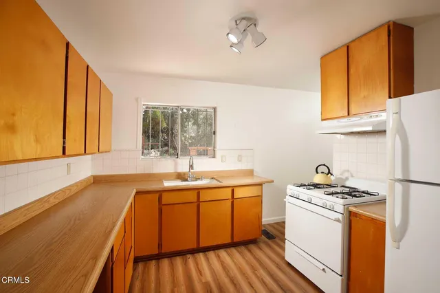 a kitchen that has a sink and a stove in it