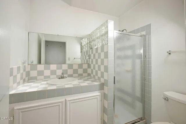 a bathroom with a granite countertop sink a mirror and a shower