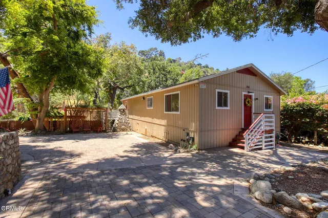 a view of a house with a tree in front of it