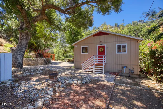 a view of a house with a yard and tree